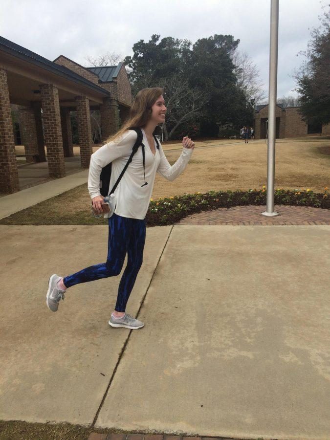 Senior Riley Grossnickle running to class in her fitness attire. (Photo by Lizzi Clayton)