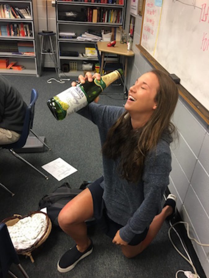 Junior Ellie Peterson gets on one knee because she was so excited for her sparkling grape juice!
