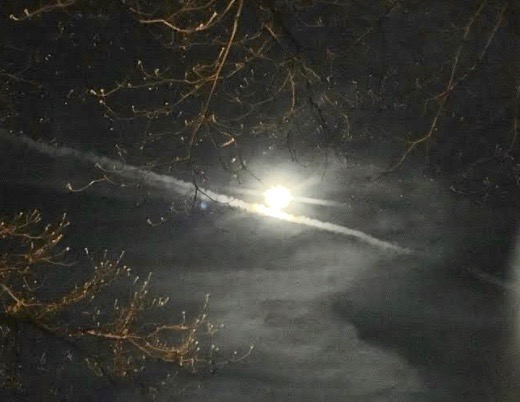 A jet stream appears across the bottom of the full moon in Macon at 9 p.m. Tuesday night