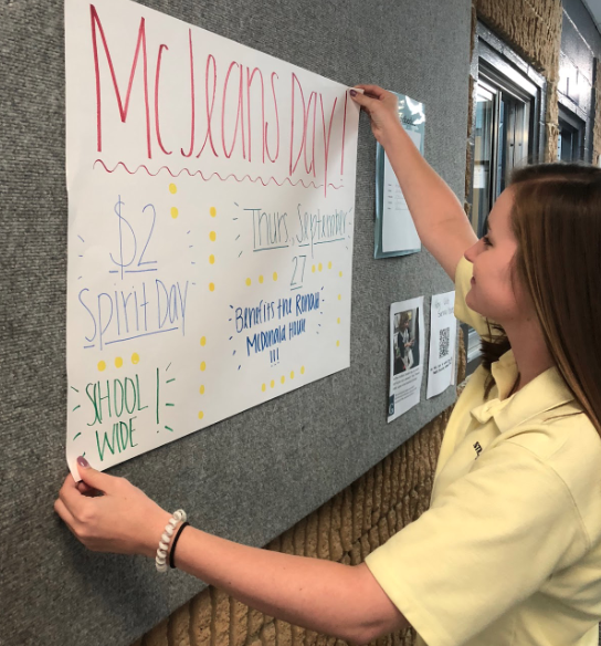 Senior Holland Schell puts up a poster promoting McJeans Day