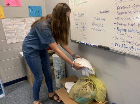 Sophomore Emily Hunt donates an item to the drive box.