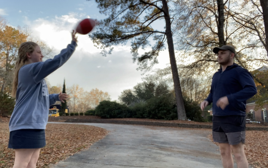 EmmaJane Canady tosses football in yard with her brother, Carter